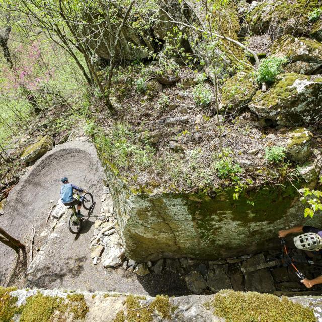 Two men mountain biking through a narrow pathway on the Monument Trails at Mount Nebo 